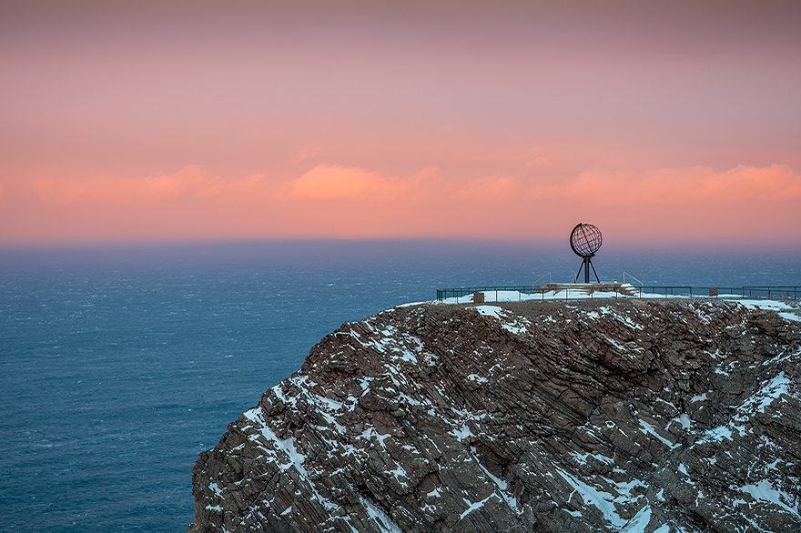Globus auf der Felsklippe am Nordkap im Sonnenuntergang