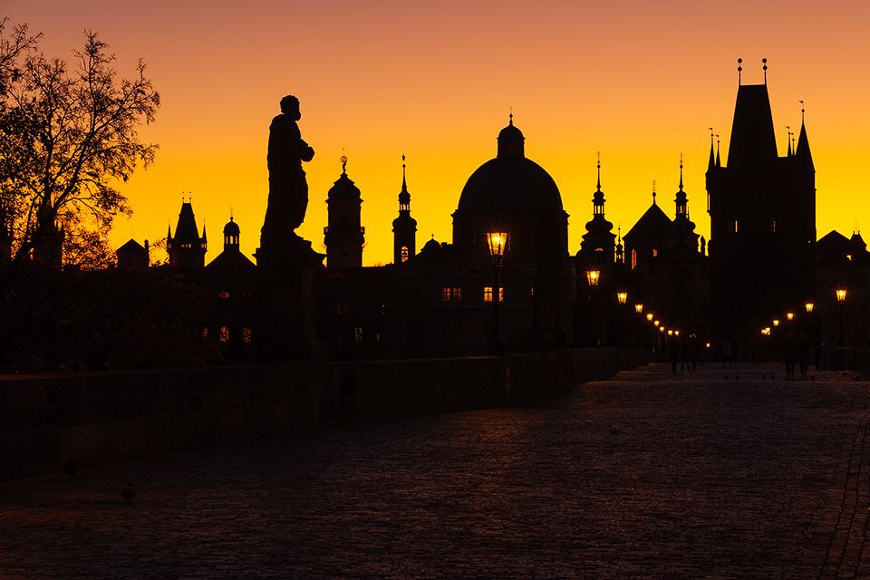 Tuerme und Kuppeln der Prager Altstadt im Sonnenaufgang